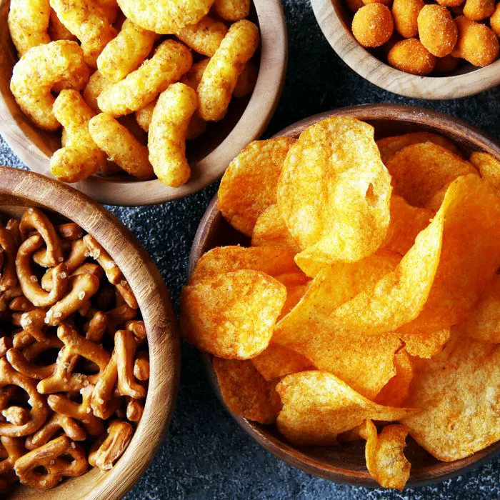 Salty snacks displayed in wooden bowls for serving.