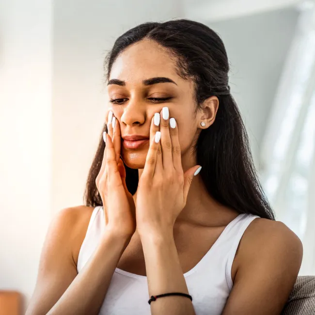Woman applying serum to her face