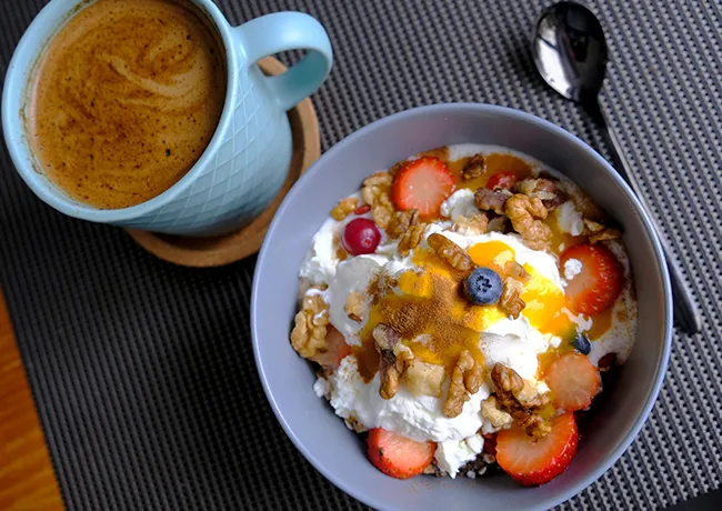 Greek yogurt parfait topped with berries, walnuts, and chia seeds.