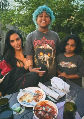 Saint West showcases his new blue hair in a playful pose.