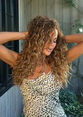 Khloe Kardashian showcases her stunning curly brown hair in a glamorous photo.
