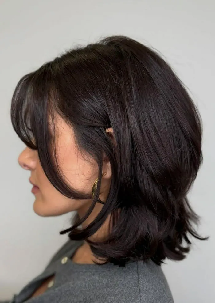 Woman with black hair showcasing a chic slip bob hairstyle.