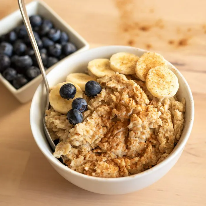"Bowl of oatmeal topped with banana and blueberries"