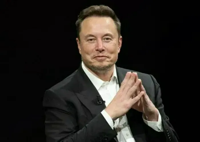 "Elon Musk smiling at the camera"