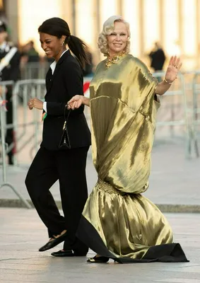 "Pamela Anderson at Vogue World in Milan wearing a gold dress"