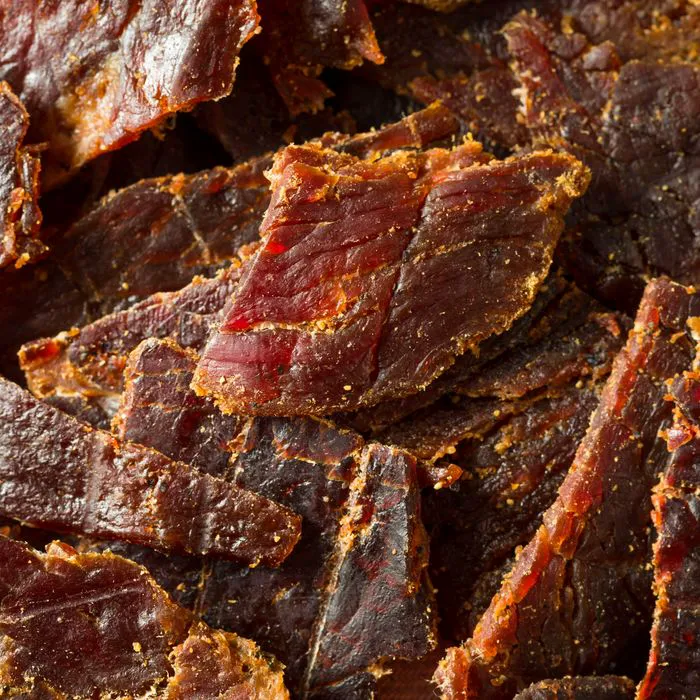 "Beef jerky pieces on a wooden board"