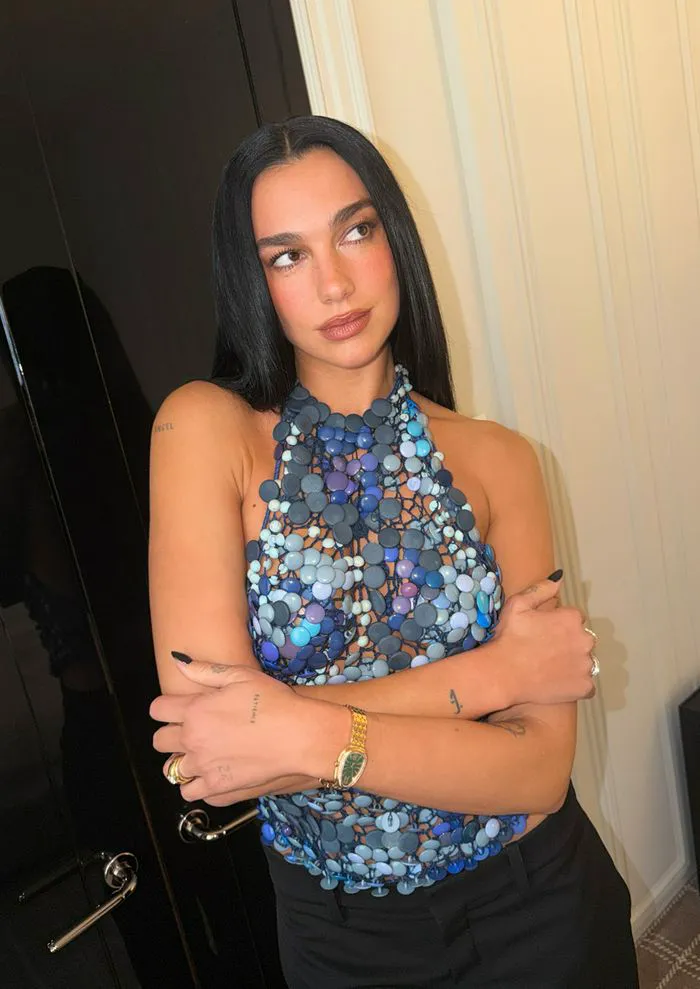 "Dua Lipa wearing blue buttons top with black trousers"