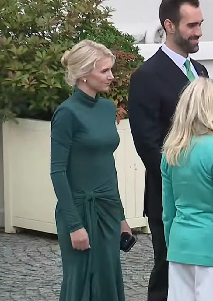 Natalie Harp in a stylish green dress at an event.