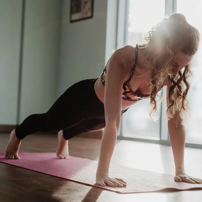 "Woman doing a Pilates plank at home"