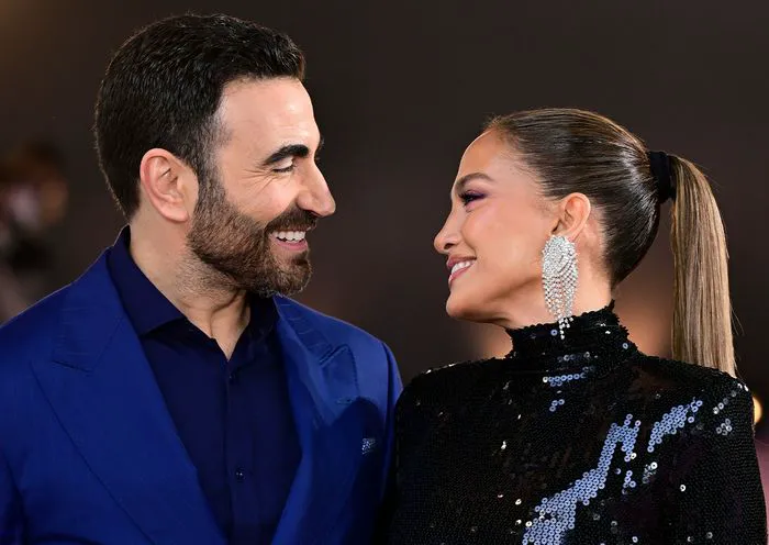 Jennifer Lopez and Brett Goldstein smiling at each other