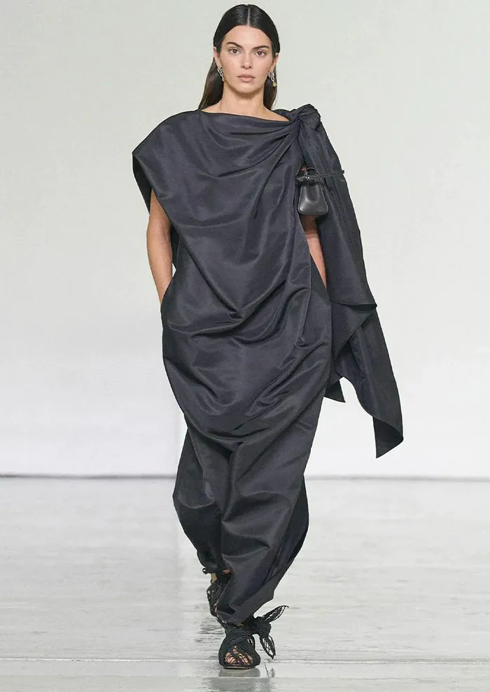 "Kendall Jenner wearing a black draped gown at Bottega Veneta show"
