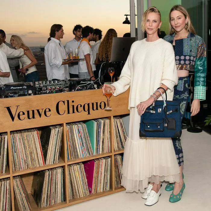 "Charlize Theron wearing knit sweater and tiered maxi skirt"