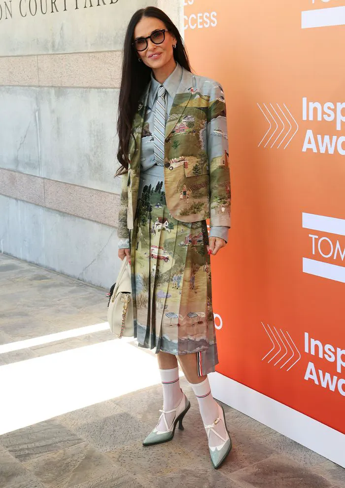 Demi Moore in a stylish landscape print skirt suit with heels.