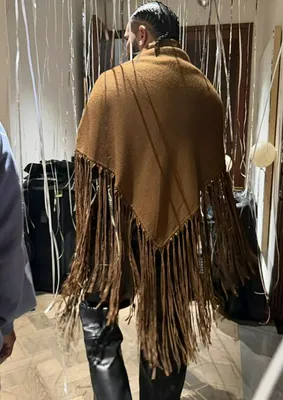 "Drake wearing a brown fringe shawl at a birthday party"