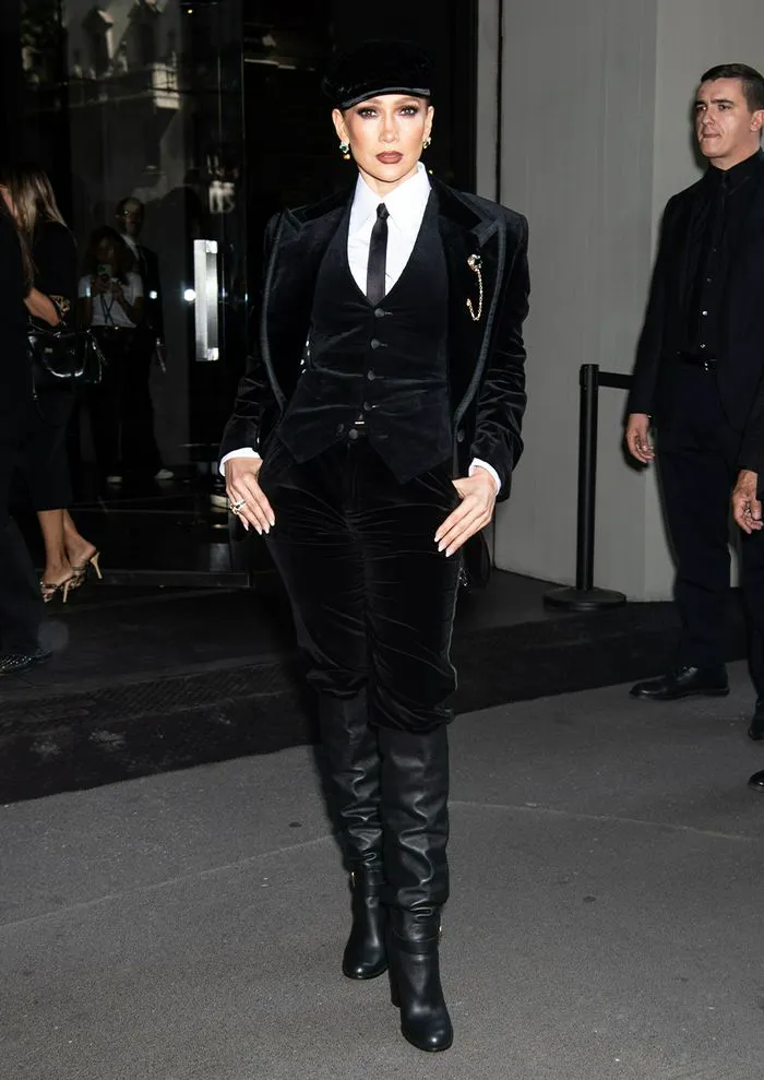 "Jennifer Lopez wearing a black velvet waistcoat and flat cap"