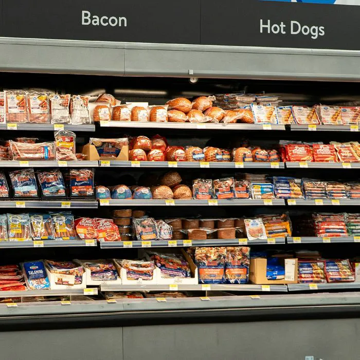 Supermarket cooler aisle filled with various beverages.