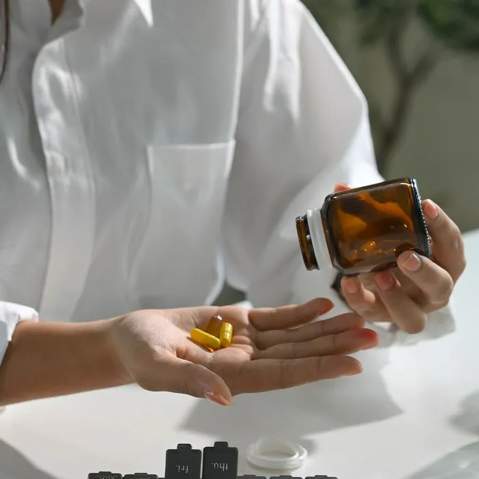Woman pouring supplements into her hand for health.